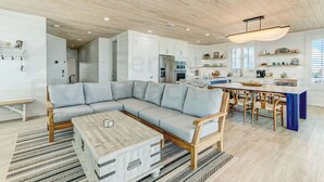 A modern kitchen with white cabinets, a built-in oven, and a dining area with a wooden table and chairs. - 226 South Fletcher 3rd Floor (Fernandina Beach)