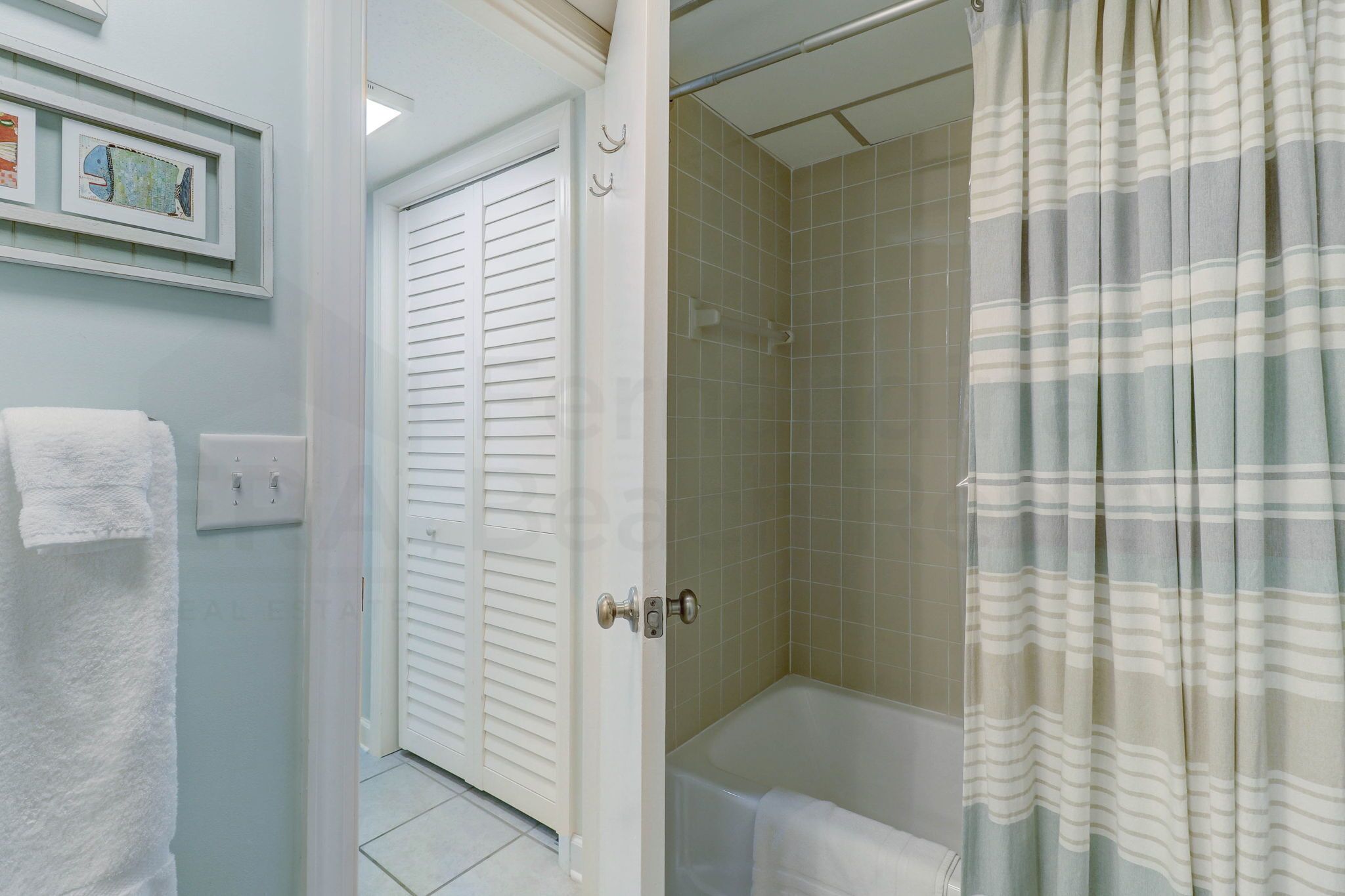 Une salle de bain équipée d’une douche, d’une baignoire et d’une porte donnant sur une autre pièce.