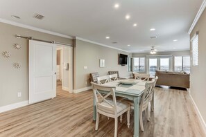 A dining area with a table and chairs, a ceiling fan, and a television on the wall. - 2958 S Fletcher Ave (Fernandina Beach)