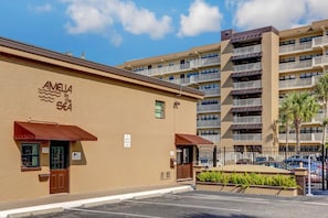 A hotel with a sign reading "AMELIA by the Sea" and a parking area with a sign indicating "10 MINUTE PARKING ONLY". - 6th Floor, Oceanfront Condo Easy Beach Access via Boardwalk & Exclusive Fishing Pier (Fernandina Beach)