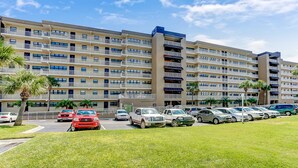 A multi-story hotel with a parking lot. - 6th Floor, Oceanfront Condo Easy Beach Access via Boardwalk & Exclusive Fishing Pier (Fernandina Beach)