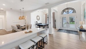 A spacious kitchen with a bar area, a dining table, and a pool table. - Fpc228 (Punta Gorda)