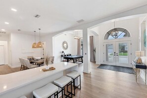 A spacious kitchen with a bar area, a dining table, and a pool table. - Fpc228 (Punta Gorda)