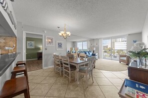 A spacious kitchen with a dining area, large windows, and a view of the city. - South Hampton 301 (Myrtle Beach)