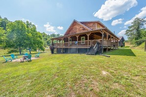 A wooden cabin with a porch, outdoor seating, and a grassy yard. - Hot Tub, Wifi, Firepit - Hazelbrook Haven (Mize)