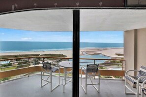 Ein Balkon mit Blick auf den Strand und das Meer.