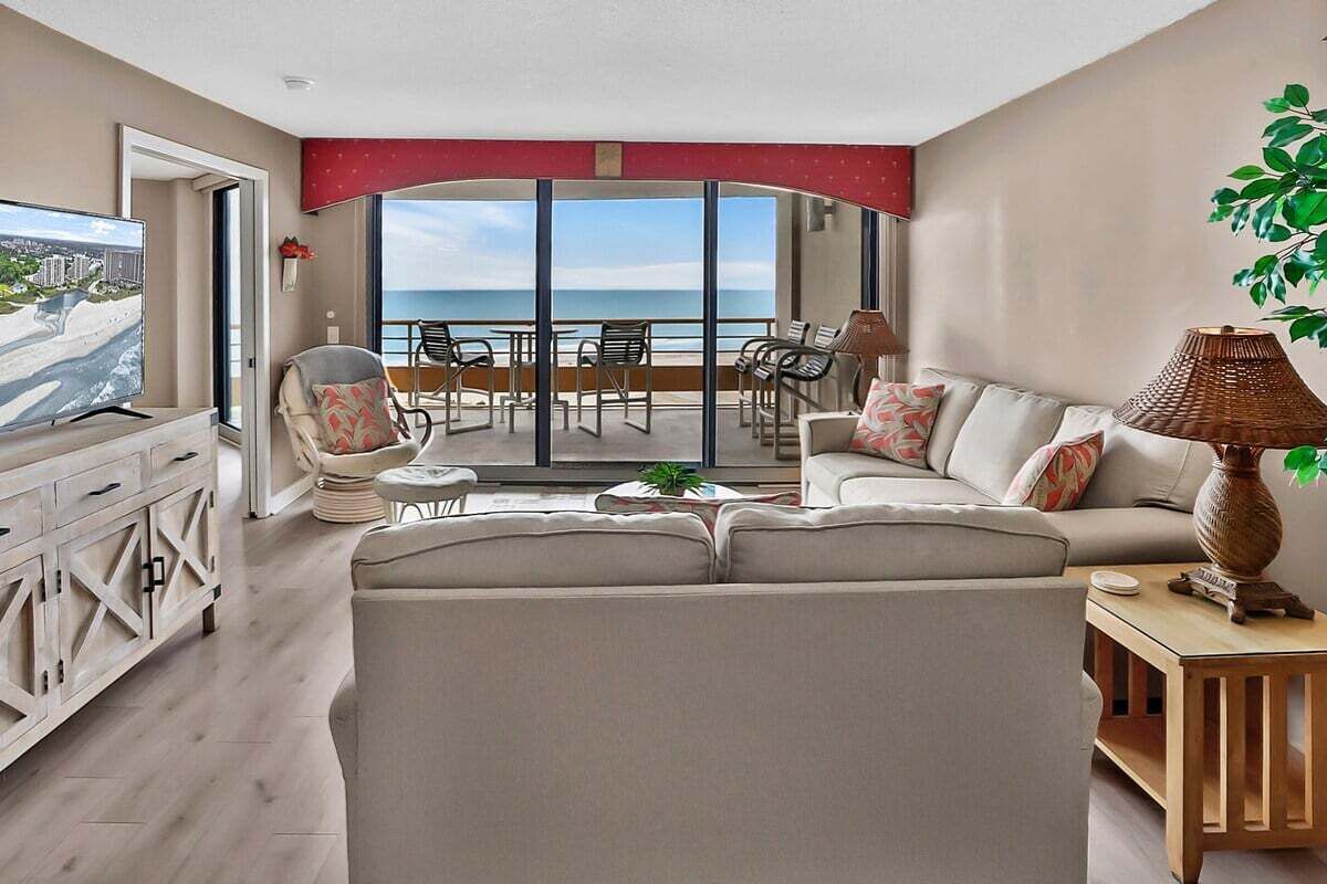 A modern living room with a sofa, TV, and dining area.