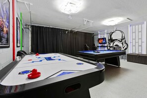 A pool table with a Star Wars-themed design, a pool cue, and a Star Wars helmet decoration. - Dvl2638 (Kissimmee)