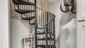 A spiral staircase with black railings and a white wall. - Cozy 1-bedroom Retreat in Tulsa (Tulsa)