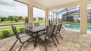 A covered patio with a pool, outdoor furniture, and a view of the neighborhood. - Emt9000 (Kissimmee)