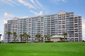 A multi-story hotel with numerous balconies and a well-maintained lawn in the foreground. - North Tower 208 (North Myrtle Beach)