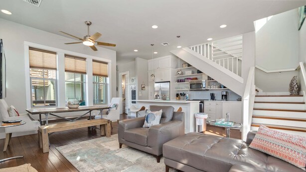A modern living room with a sofa, a coffee table, and a dining area. - The Oyster House - Pet Friendly! Golf Cart Included! (Port Aransas)