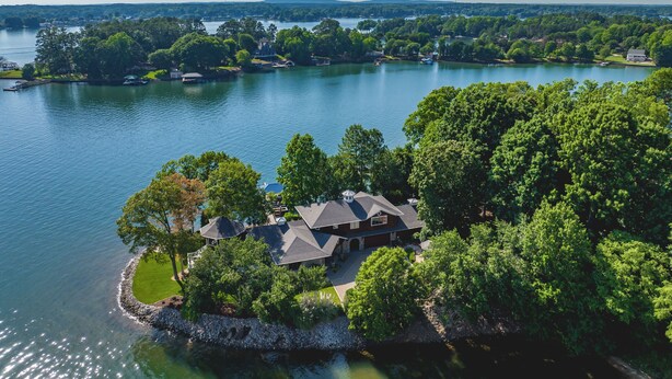 Een vakantiehuis aan het meer, met een groot huis omringd door bomen en een steiger.