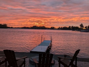Sonnenuntergangblick von einer Pier mit Stühlen und einem Tisch.