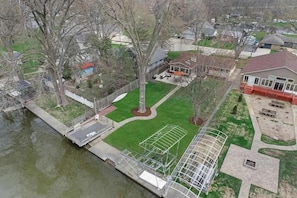 An aerial view of a residential area with a house, a tennis court, and a dock. - Meyers Bay Sunset Lakefront Cottage in Fox Lake w/ Boat Pier (Fox Lake)