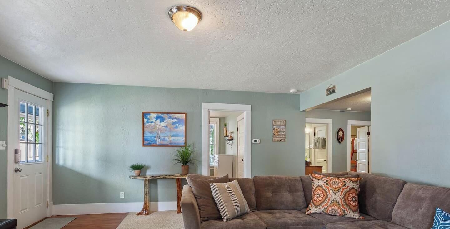 A living room with a couch, a small table, and a painting on the wall.