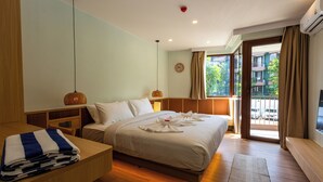 Ein Hotelzimmer mit Bett, Nachttischen, einem Schreibtisch, einem Fernseher und einem Balkon mit Aussicht.