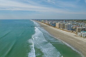 An aerial view of a coastal city with a beach, a pier, and high-rise buildings along the shore. - Sea La Vie Villa 3BD Beach Retreat Fence Yard (North Myrtle Beach)