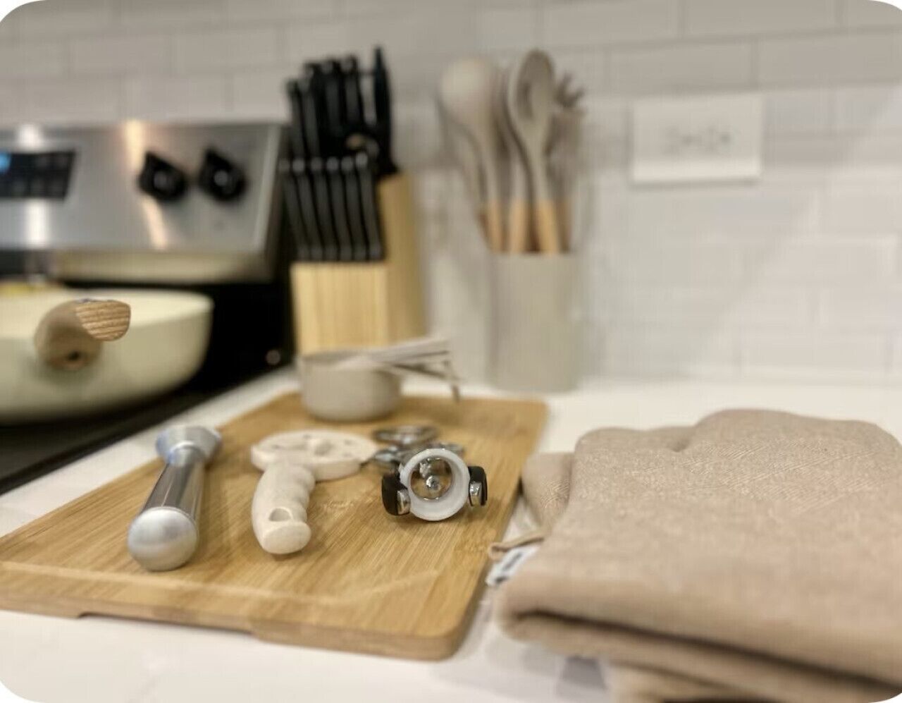 Un ripiano della cucina con un tagliere, utensili di misurazione e un asciugamano.