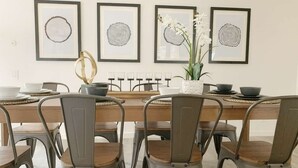 A dining area with a wooden table, metal chairs, and framed artwork on the wall. - Marbella Lane - 4BR Alluring Home (Union City)