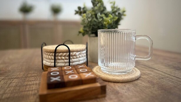 A clear glass mug on a coaster, wooden blocks with 'XOXO' on them, and coasters on a wooden table. - Workerfriendly,kingbed,a+location,washer,wifi,pool (Sherman)