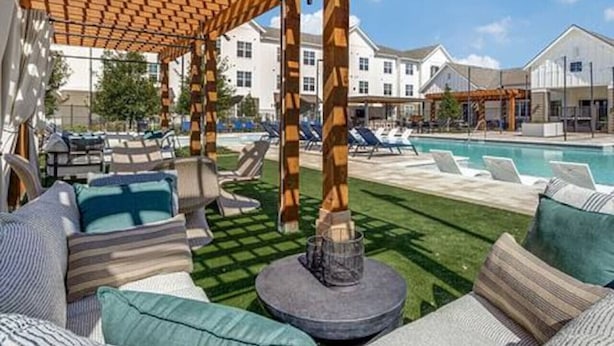 A covered outdoor seating area with a pool in the background. - Workerfriendly,washer/dryer, Gym,pool, A+ Location (Sherman)