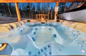 A hot tub with a view of a forest at dusk. - 6 Bedrooms + Hot Tub + Game Room + Movie Theater (Hawley)