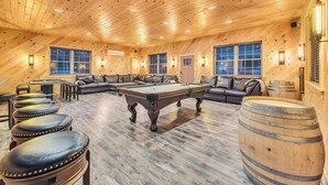 A wooden interior with a pool table, leather seating, and wooden barrels. - 6 Bedrooms + Hot Tub + Game Room + Movie Theater (Hawley)