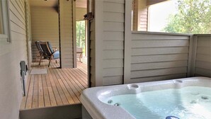 A hot tub on a wooden deck with a view of a chair and a table. - Lone Eagle Landing 2 (Bend)