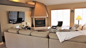 A living room with a sofa, a fireplace, a television, and a lamp. - Lone Eagle Landing 2 (Bend)