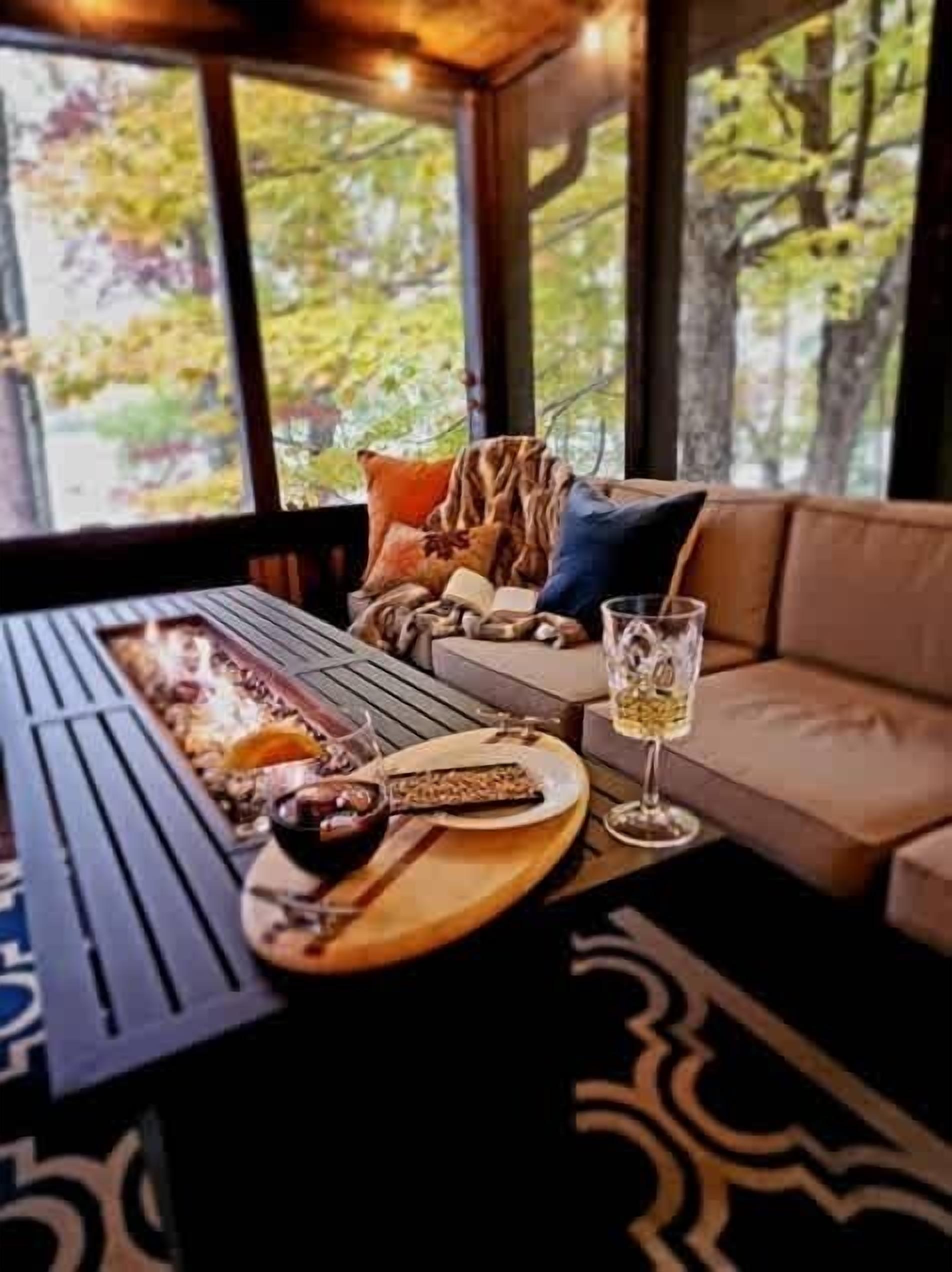 A cozy seating area with a table, cushions, and a glass of wine.