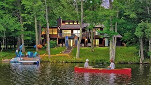 A lakeside cabin with a dock, a canoe, and a boat. - Lakefront Hot Tub Canoes Game Room Wood FP (Gouldsboro)