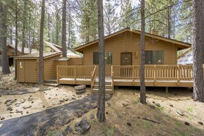 A cabin with a porch, a small shed, and a covered outdoor area. - Timber 12 (Bend)