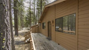 A cabin with a wooden exterior, a porch, and a door marked with the number 12. - Timber 12 (Bend)