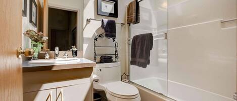 A bathroom with a toilet, sink, and shower.