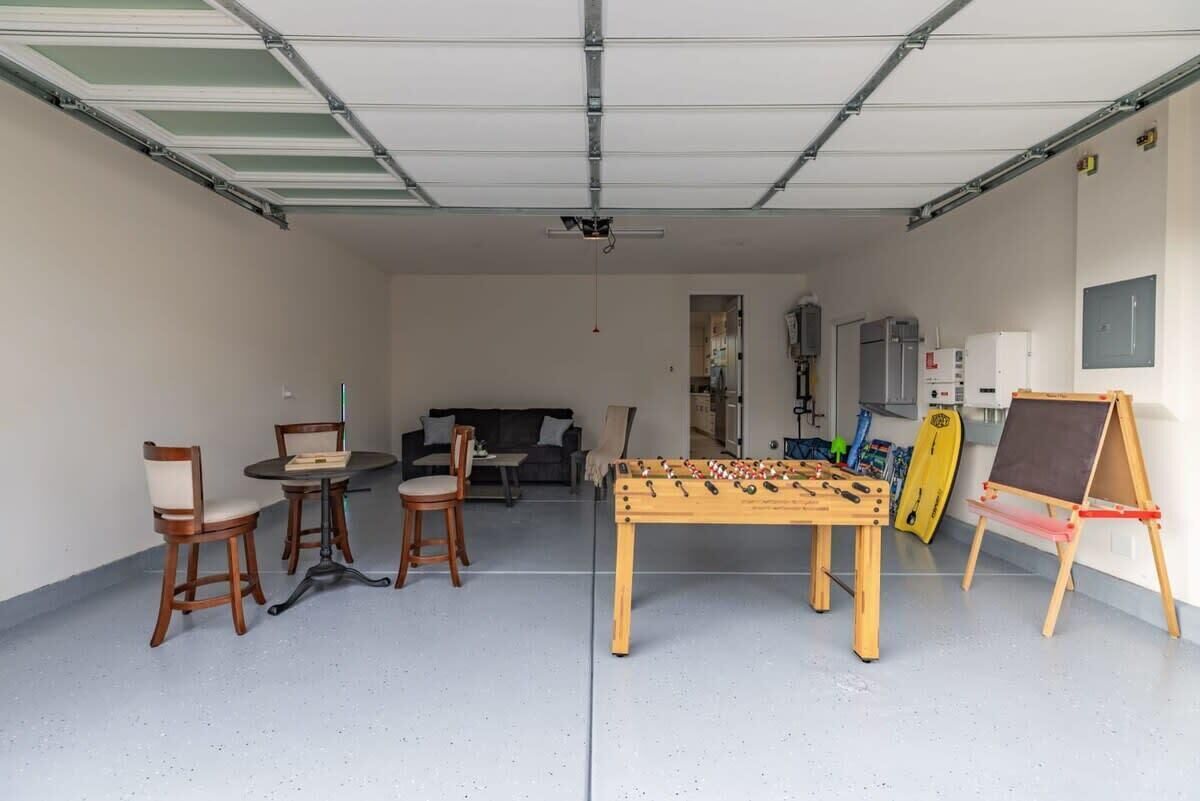 Eine Garage mit einem Fußballtisch, Stühlen und einem Tisch.