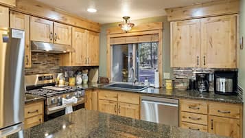 Una cocina con armarios de madera, un refrigerador de acero inoxidable, una estufa y un lavavajillas.