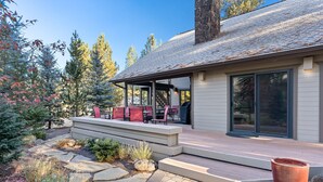 Une maison moderne dotée d’un patio couvert, d’un chemin en pierre et d’un espace salon extérieur.
