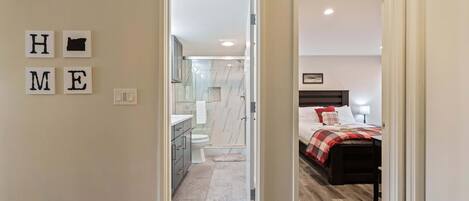 A bedroom with a bed, a bedside table, and a nightstand.