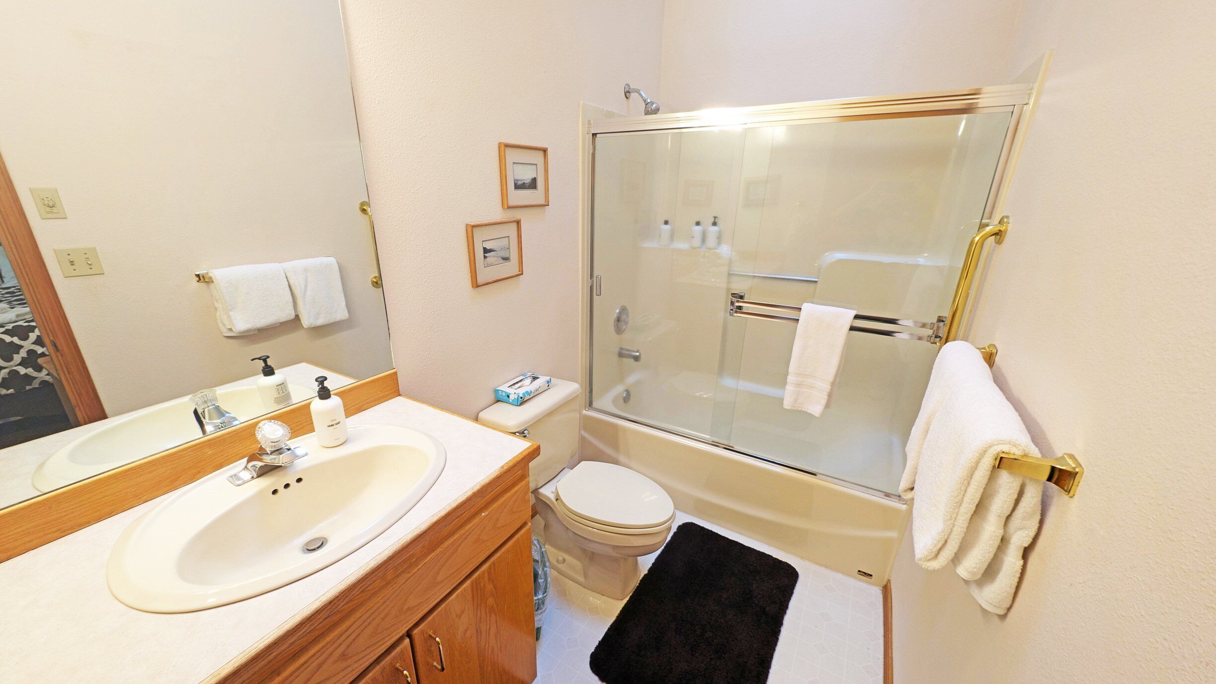 A bathroom with a sink, toilet, and glass-enclosed shower.