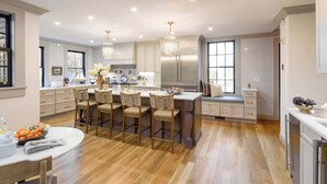 A modern kitchen with a central island, bar stools, and a dining table. - Sanctuary Suite at The Royce, Newport (Newport)