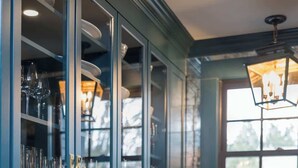 A modern kitchen with teal cabinetry, stainless steel appliances, and a large window providing natural light. - Sanctuary Suite at The Royce, Newport (Newport)