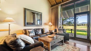 A cozy living room with a leather sofa, a wooden coffee table, and a large mirror.