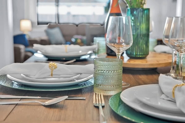 A dining table set with plates, cutlery, and a glass.
