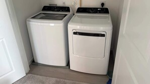 A laundry room with two white washing machines and a dryer. - @ Marbella Lane - Tranquil Escape in Texas Pines (Splendora)