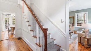A staircase with wooden steps and white railings leading to a second-floor landing. - Regatta Suite at The Royce Refined Newport Charm (Newport)