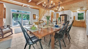 A spacious dining area with a wooden table, chairs, and a chandelier. - Lake Wallenpaupack Lakefront Private Boat Slip (Greentown)