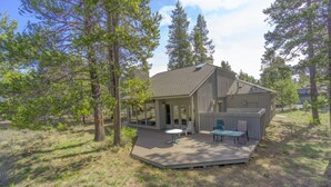 A cabin with a deck, a covered patio, and a large window overlooking a forested area. - Maury Mountain 36 (Bend)