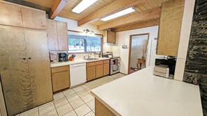 A kitchen with wooden cabinets, a dishwasher, a stove, and a refrigerator.