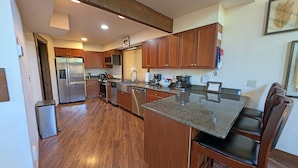 A modern kitchen with wooden cabinets, stainless steel appliances, and a granite countertop. - Indian 3 (Bend)